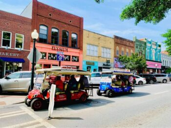 During the Downtown Tour the golf carts pass colorful storefronts line the streets and pass by in a lively downtown area.
